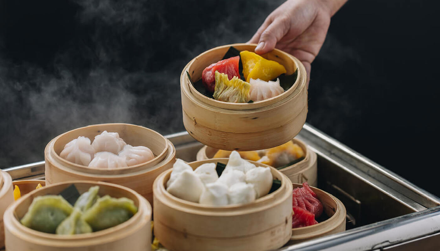 Stacked dumpling steamers full of delicious different coloured dumplings